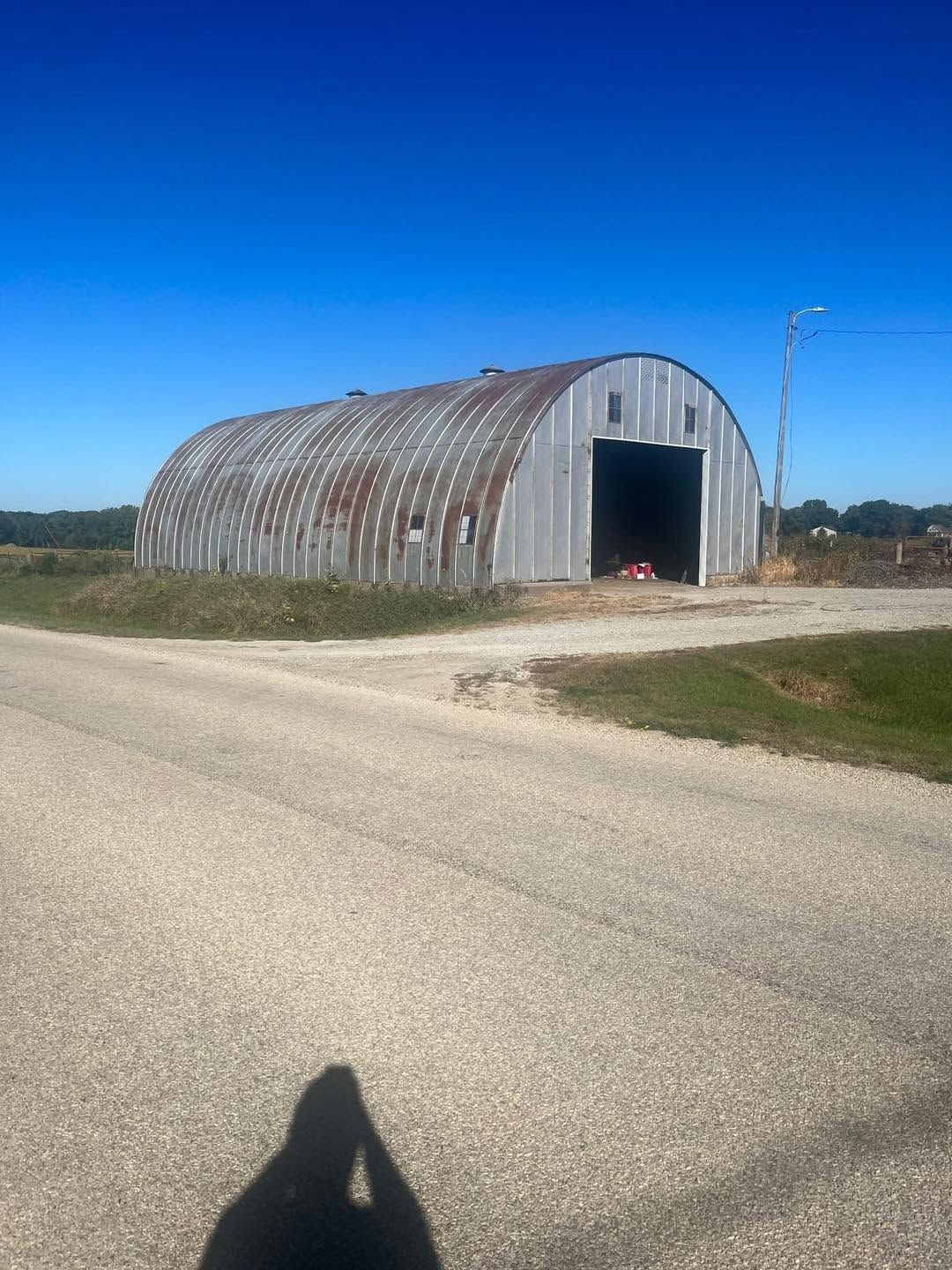 Arched Quonset building with rust streaks across the metal